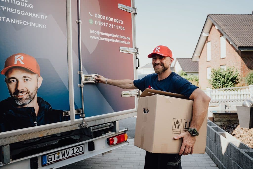 Mitarbeiter lädt einen Karton in den Transporter