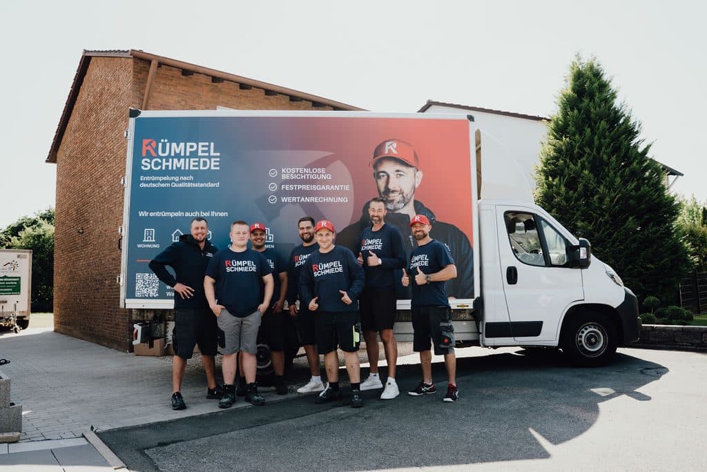 Mitarbeiter der Rümpelschmiede in einer Reihe vor dem Transporter